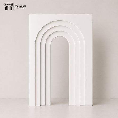 Modern white layered arch backdrop standing in a minimalist studio setting with soft neutral tones and elegant curved design for party and event decor.