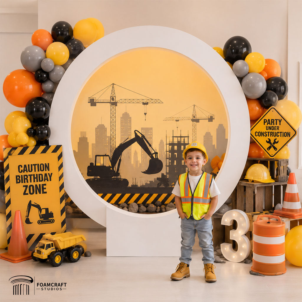 Construction-themed birthday party setup using the Halo Ring Backdrop with yellow and black balloons, toy trucks, and kids construction décor.